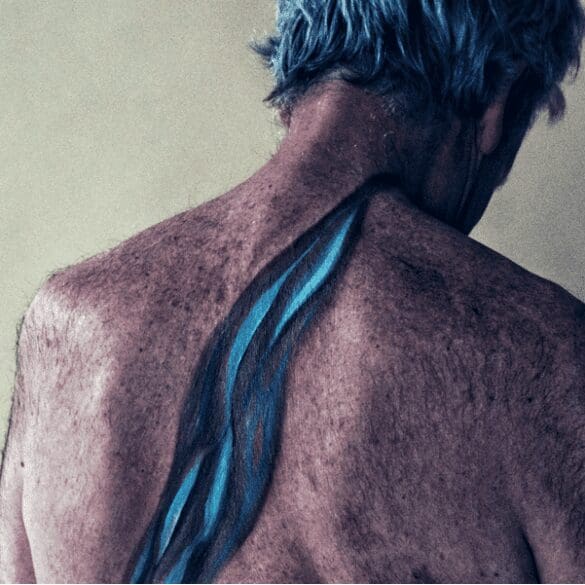 A body painting on the back of an older white man, that shows how fresh water carves out rock.
