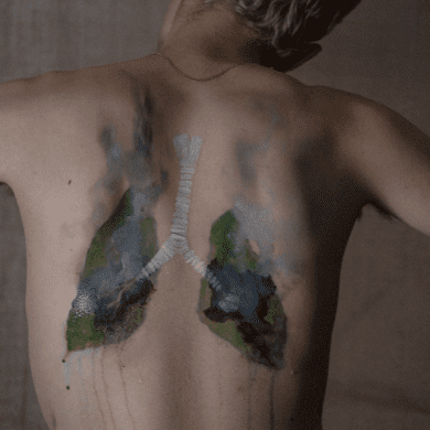 Burning lungs painted onto the back of a white man depicting land systems change.