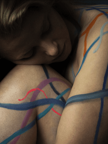 "Artwork titled 'Microplastic Nexus' depicting the novel entities planetary boundary through a body painting on Dr. Imogen Napper, based on her enlarged microscopic imagery of microplastics, symbolising the pervasive spread of microplastics from synthetic clothing into water and air."