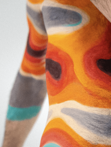 Climate heat maps painted onto the arms and torso of a man's body.